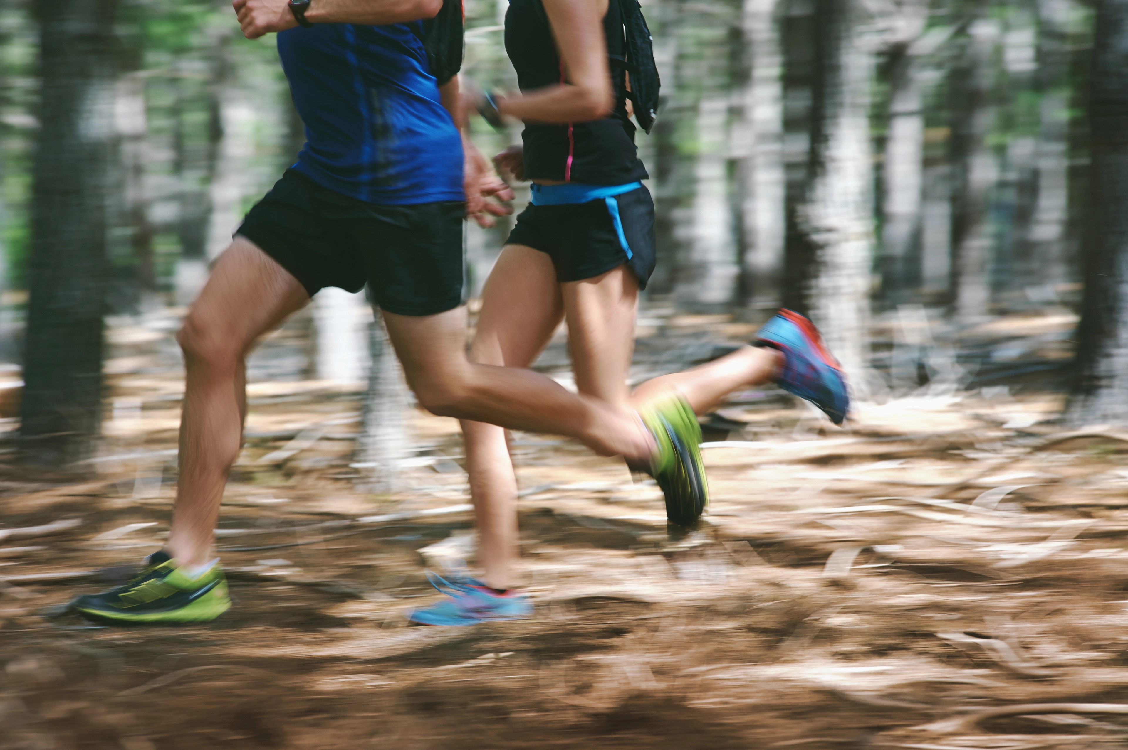 Homme et femme courant ensemble dans les bois